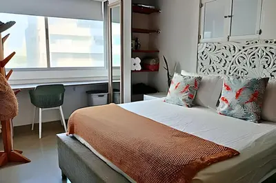 a bedroom with a bed and a window and a chair at Precioso Apto a pasos de la playa, ubicación ideal in Cartagena de Indias