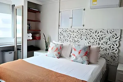 a bedroom with a bed with white sheets and pillows at Precioso Apto a pasos de la playa, ubicación ideal in Cartagena de Indias