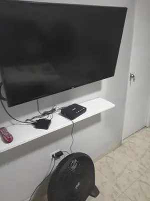 a flat screen tv on a shelf with a fan at Back house gallery in Cartagena de Indias