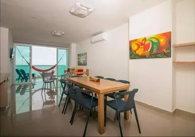 a dining room with a wooden table and chairs at Apto De 3 Hab con Vista y Salida directa Al Mar in Estación El Salto