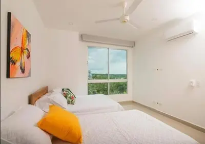 two beds in a white room with a window at Apto De 3 Hab con Vista y Salida directa Al Mar in Estación El Salto