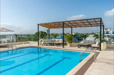 a swimming pool with a pergola next to a building at Apartasuite en Cartagena in Cartagena de Indias