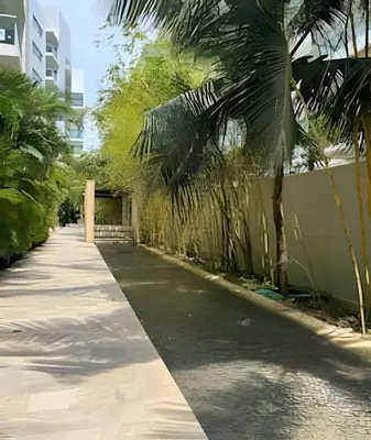 a sidewalk with palm trees next to a building at Beachfront Paradise with Pools and Spa in Cartagena de Indias