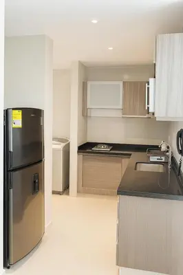 a kitchen with a stainless steel refrigerator and cabinets at Apto Grand- Ithiel in Barranquilla