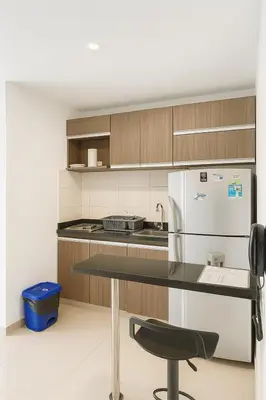 a kitchen with a table and a white refrigerator at Apto Grand- Ithiel in Barranquilla