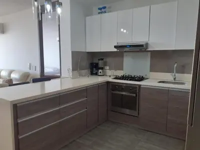 a kitchen with white cabinets and a stove top oven at Apartamento en la Boquilla, Cartagena in Cartagena de Indias