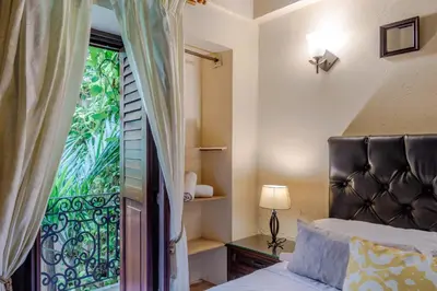 a bedroom with a bed and a door with a window at Estrella de San Pedro B&B in Cartagena de Indias