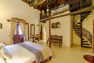 a bedroom with a large bed and a staircase at Estrella de San Pedro B&B in Cartagena de Indias