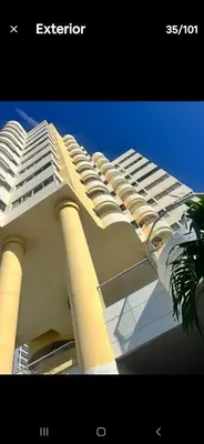 a white building with a palm tree in front of it at Confortable in Cartagena de Indias