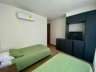 a bedroom with a green bed and a tv at Sunsets in El Cabrero - Cartagena in Cartagena de Indias
