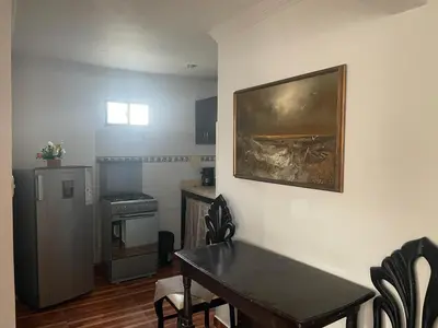 a kitchen with a dining room table and a painting on the wall at Posada Encanto Cartagena in Cartagena de Indias