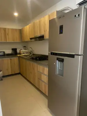 a stainless steel refrigerator in a kitchen with wooden cabinets at La Rosita in Puerto Colombia