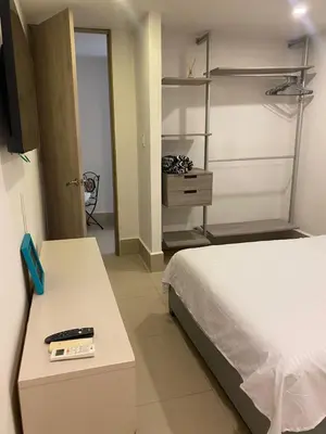 a bedroom with a bed and a desk with a remote control at La Rosita in Puerto Colombia