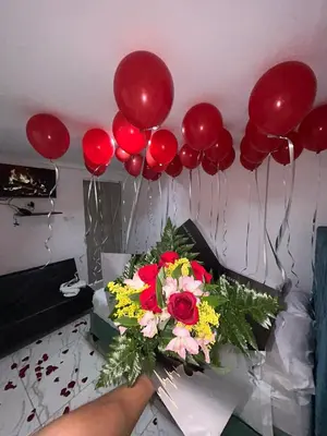 a table with a bouquet of flowers and red balloons at Lago Hotel Cartagena in Estación El Salto