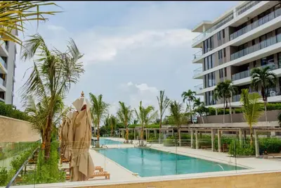 a swimming pool with palm trees and a building at Luxury Oasis Private Pool Wine BBQ and Sea in Cartagena de Indias
