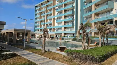 a large apartment building with a swimming pool and palm trees at De Luxe acogedor con vistas al Mar y Atardeceres in Maizal