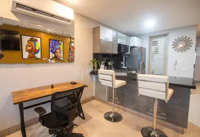 a kitchen with a table and two white chairs at Oceanview Suite with two Pools, Gym & Guest Access in Cartagena de Indias