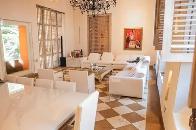a living room with white furniture and a chandelier at Hotel casa santiago botero in Cartagena de Indias