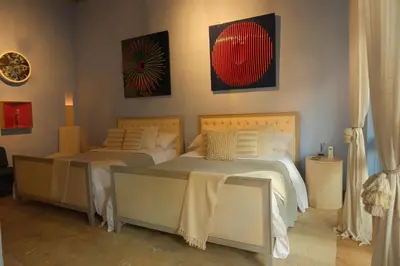 a bedroom with two beds and two tables at Hotel casa santiago botero in Cartagena de Indias