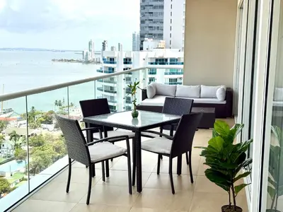 a balcony with a table and chairs and a couch at Moderno Apartamento 1504 in Cartagena de Indias