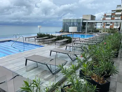 a row of tables next to a swimming pool at Moderno Apartamento 1504 in Cartagena de Indias