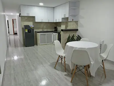 a kitchen with a white table and white chairs at Casa 19 in Ciénaga