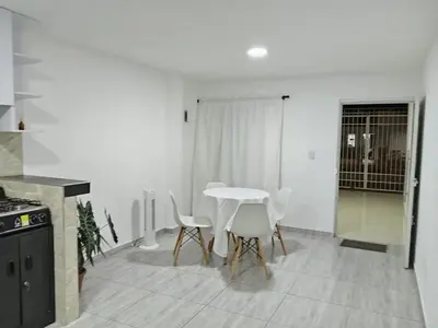 a white kitchen with a table and chairs in it at Casa 19 in Ciénaga