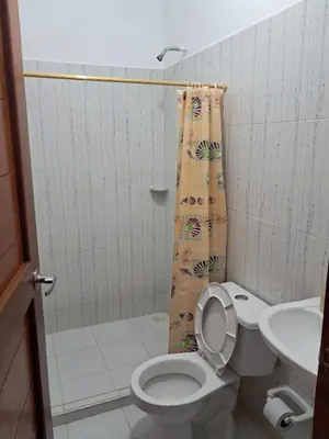 a bathroom with a toilet and a shower curtain at Hospedaje Mango y Mar Habitaciones in Coveñas