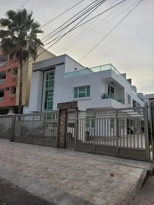 a white house with a fence and a palm tree at Casa 4 Barrio El Prado in Barranquilla