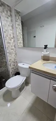 a white bathroom with a toilet and a sink at Apartamento Plazuela Portal Del Prado in Barranquilla