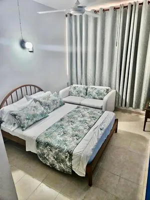 a bedroom with two beds and a couch at Hermoso apartamento caribeño Bocagrande Cartagena 100 metros in Cartagena de Indias