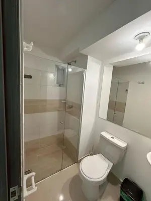 a bathroom with a toilet and a glass shower at Apartamento moderno en norte de la ciudad in Barranquilla