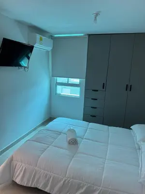 a large white bed in a room with a blue light at Apartamento moderno en norte de la ciudad in Barranquilla