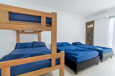 two bunk beds with blue sheets in a room at Casa Vianca Beach in Estación El Salto