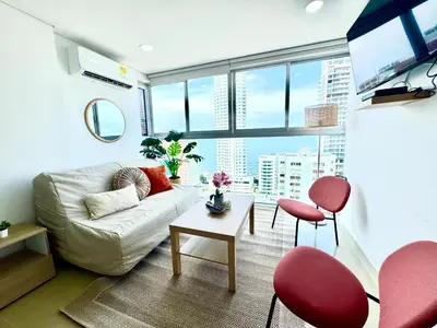 a living room with a white couch and red chairs at magnoloft1104 in Cartagena de Indias