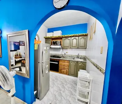 a kitchen with a refrigerator and a clock on the wall at Apartamento playa Bocagrande Los Delfines Cartagena in Cartagena de Indias