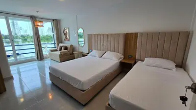 a hotel room with two beds and a couch at Loft MR1-4G facing the sea in a high level neighborhood in Cartagena de Indias