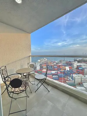 a balcony with a table and chairs and a view of a harbor at Lujoso alojamiento empresarial en Cartagena in Cartagena de Indias