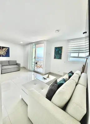 a white living room with a couch and a table at Excepcional apartamento en zona de negocios in Cartagena de Indias