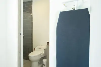 a bathroom with a toilet and a blue door at Serene Bay by Wynwood House in Cartagena de Indias