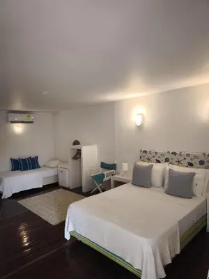 a large bedroom with two beds and a couch at Playa Banana Manzanillo del Mar in Cartagena de Indias
