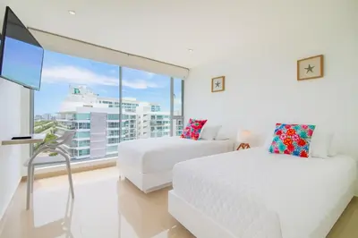 a bedroom with two beds and a large window at Apartamento de Ensueño!! Sonesta Cartagena Salida Playa Vistas WOW Morros in Cartagena de Indias