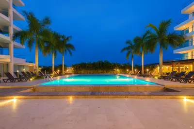 a swimming pool with palm trees and a building at Apartamento de Ensueño!! Sonesta Cartagena Salida Playa Vistas WOW Morros in Cartagena de Indias
