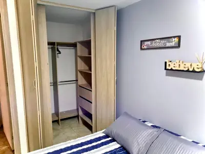 a closet with a mirror and a couch in a room at Apartamento con Vistas a la Ciudad in Barranquilla