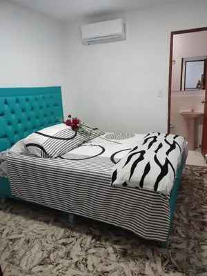 a bed with a black and white comforter and flowers on it at Hostal Marhú in Cartagena de Indias
