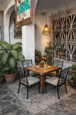 a wooden table and chairs in a patio with plants at Hostal Marhú in Cartagena de Indias