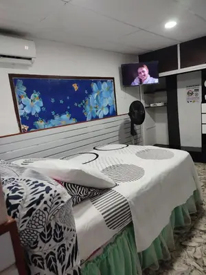 a bedroom with a bed with a tv on the wall at Hostal Marhú in Cartagena de Indias