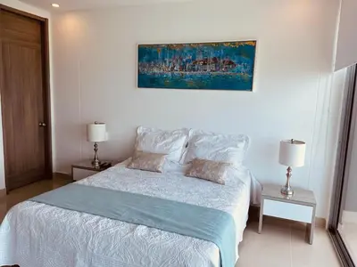 a bedroom with a bed and a painting on the wall at Hostal Costacaribeam in Barranquilla