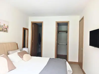 a bedroom with a bed and a flat screen tv at Lujoso Apto con Piscina Privada y salida a playa in Cartagena de Indias