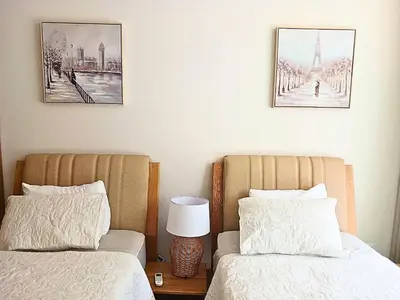 two beds in a bedroom with two pictures on the wall at Lujoso Apto con Piscina Privada y salida a playa in Cartagena de Indias